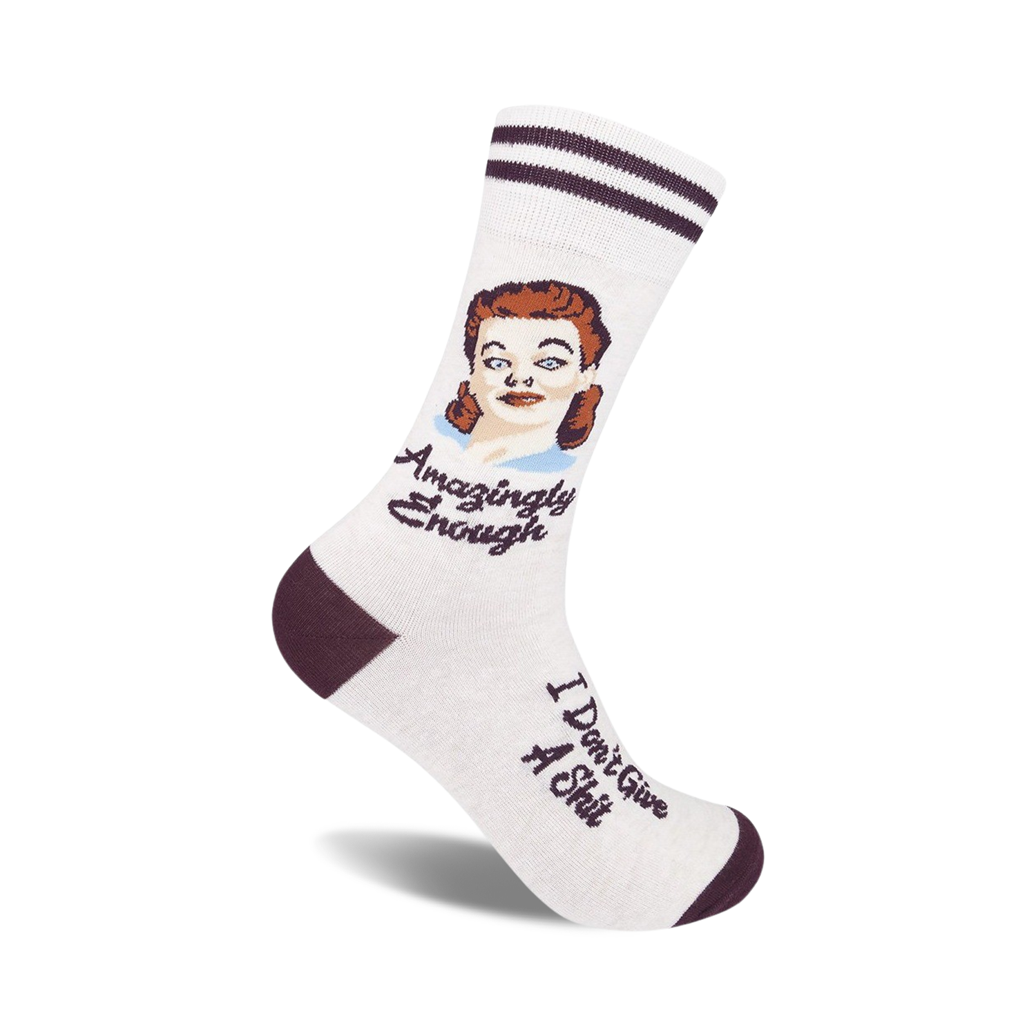 Cream crew socks with maroon stripes and a vintage illustration of a woman. Text reads 'Amazingly Enough' and 'I Don't Give A Shit'.