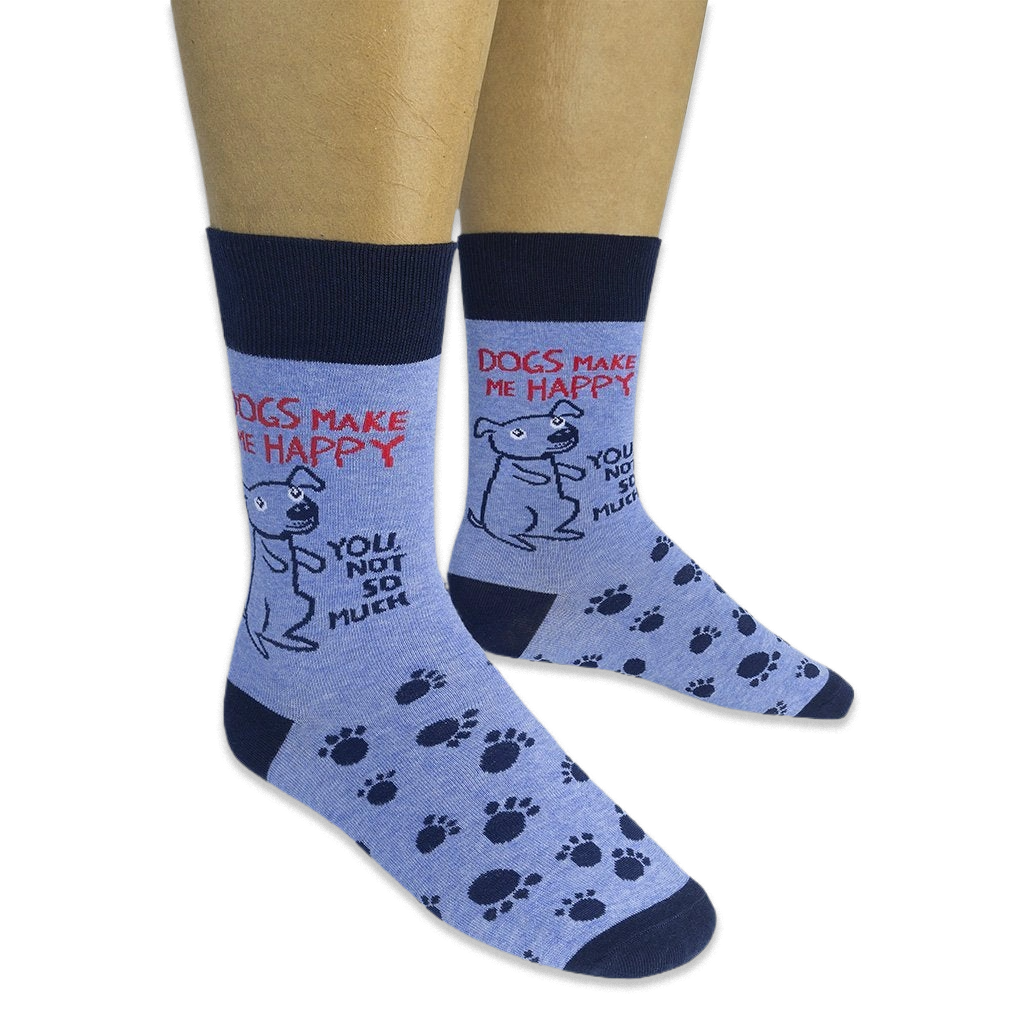 Person wearing light blue socks featuring navy paw prints, a cartoon dog, and the phrase Dogs Make Me Happy You Not So Much.