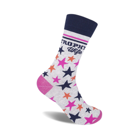 crew-length women's socks in gray with dark blue cuff, white background with "trophy wife" in dark blue, vertical pink stripes, and pink and orange stars.  