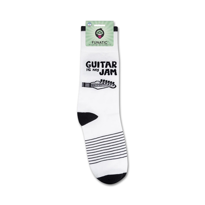 A pair of white socks with black toes and heels. The socks have a black guitar fretboard with white music notes going up the shaft. The packaging has a white background with a green tab at the top. The word 