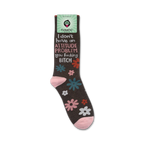 Lifestyle product shot of the 'I Don't Have An Attitude Problem' socks shown on a foot.  The socks are dark brown with pink, teal, and white flowers. The socks also feature a bold sassy message