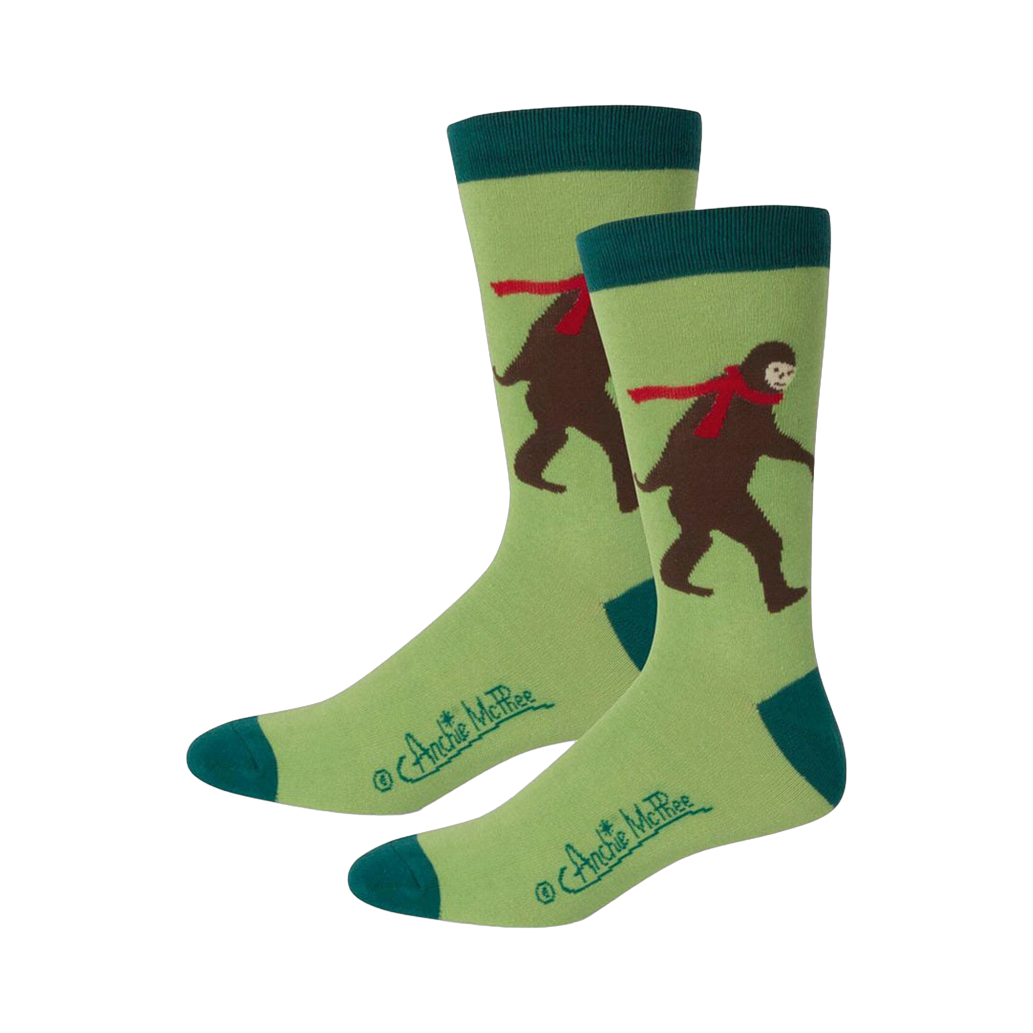 Pair of crew socks featuring a light green background, teal cuffs, and a brown Bigfoot wearing a red scarf.