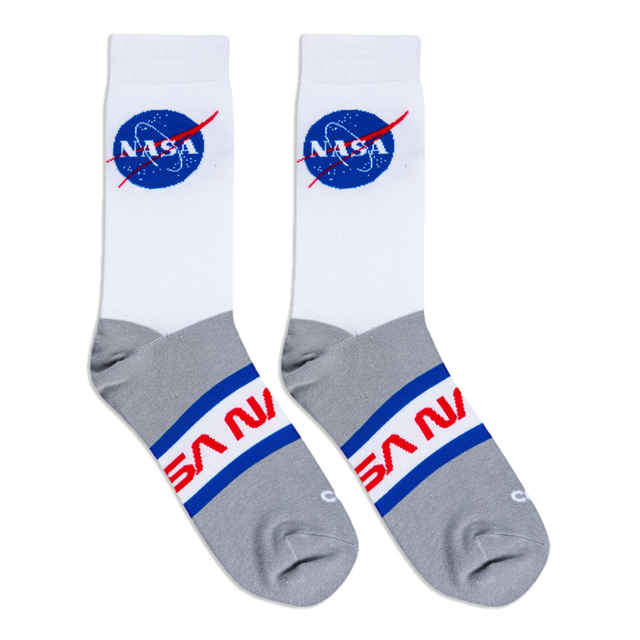 Flat lay of white and grey crew socks showing the blue NASA meatball logo on the upper and red NASA text on the foot part.
