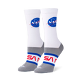 White crew socks on foot forms featuring the blue NASA meatball logo on the calf and red NASA worm text on a grey foot base.
