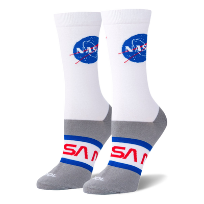 White crew socks on foot forms featuring the blue NASA meatball logo on the calf and red NASA worm text on a grey foot base.