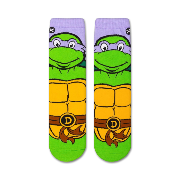 A close up of a sock with the face of Donatello from Teenage Mutant Ninja Turtles. Donatello is a turtle with green skin and a purple mask. He is smiling with his eyes closed.