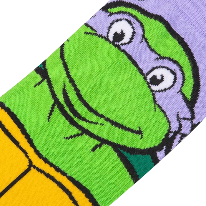 A close up of a sock with the face of Donatello from Teenage Mutant Ninja Turtles. Donatello is a turtle with green skin and a purple mask. He is smiling with his eyes closed.