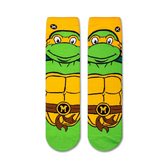 A close up of a sock with the face of Michelangelo from the Teenage Mutant Ninja Turtles on it. The sock is green with yellow and white details.