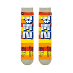 Flat lay of two Pez socks showing orange and yellow stripes, vertical block logos, and printed net weight details at the toe.