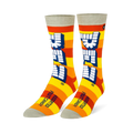 Crew socks with yellow and orange stripes, a large vertical white Pez logo, and light grey details on the toe and cuff.