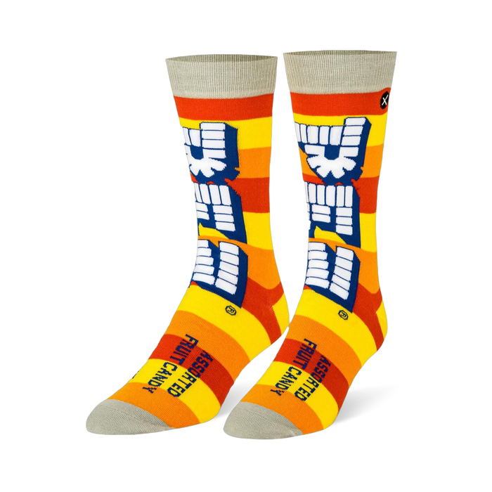 Crew socks with yellow and orange stripes, a large vertical white Pez logo, and light grey details on the toe and cuff.