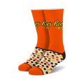 Pair of orange crew socks with Reese's Pieces logo and brown, yellow, and orange polka dots. 