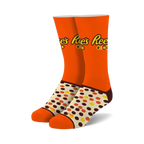 Pair of orange crew socks with Reese's Pieces logo and brown, yellow, and orange polka dots. 