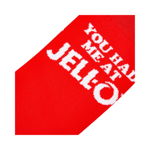 Close-up detail shot highlighting the 'You Had Me At Jell-O' text on the red sock.