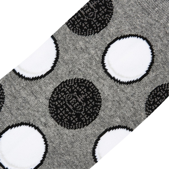 A close up of gray socks with a pattern of black and white polka dots.