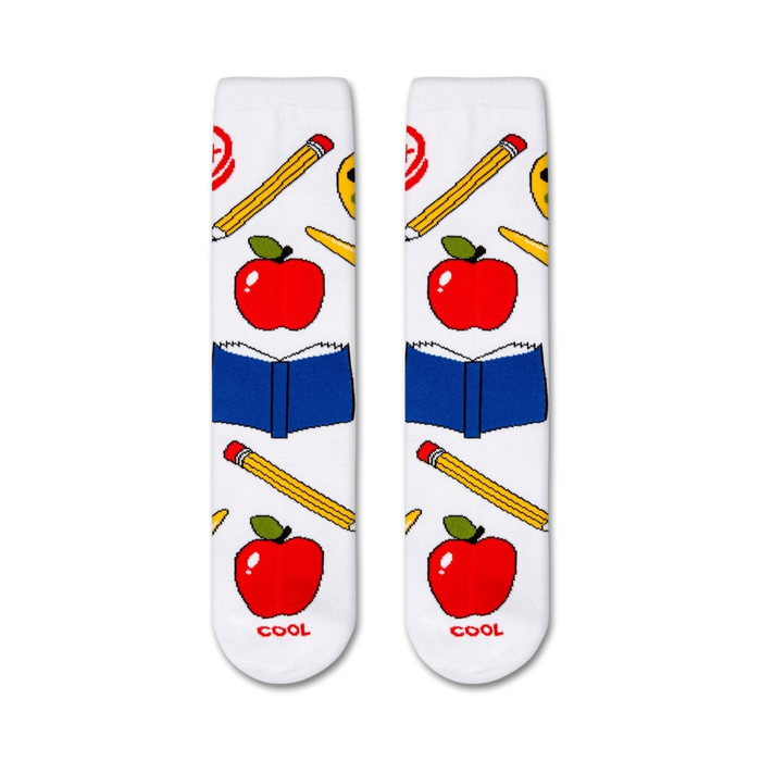 A pair of white socks with a pattern of red apples, yellow pencils, and blue books. The word 