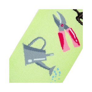Detailed close-up of the sock design, focusing on a watering can and pink gardening shears.