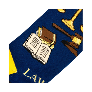 Close-up detail shot of the sock's design, focusing on the gavel, scales of justice, and open book illustrations.