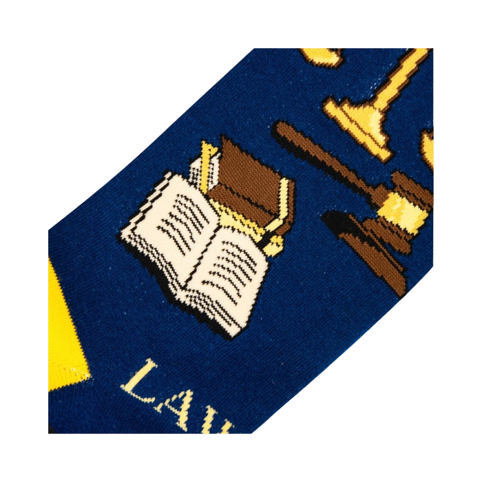 Close-up detail shot of the sock's design, focusing on the gavel, scales of justice, and open book illustrations.