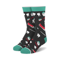 Pair of crew socks with a dark background and teal cuffs.  The design features illustrations of teeth, toothbrushes, toothpaste tubes, and dental floss.