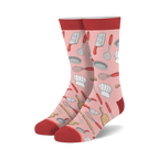 Pair of crew socks in pink, red, and cream.  Features a fun pattern of chef hats, whisks, spatulas, and other kitchen tools.