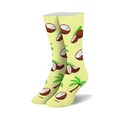 Pair of pastel yellow crew socks featuring a fun pattern of brown coconuts, coconut halves, and green palm trees.