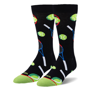 Black crew socks featuring a pattern of neon green tennis balls and blue and red rackets with a bright green toe cap.