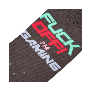 Close-up detail shot of the sock's 'Fuck Off I'm Gaming' text and pixelated design.