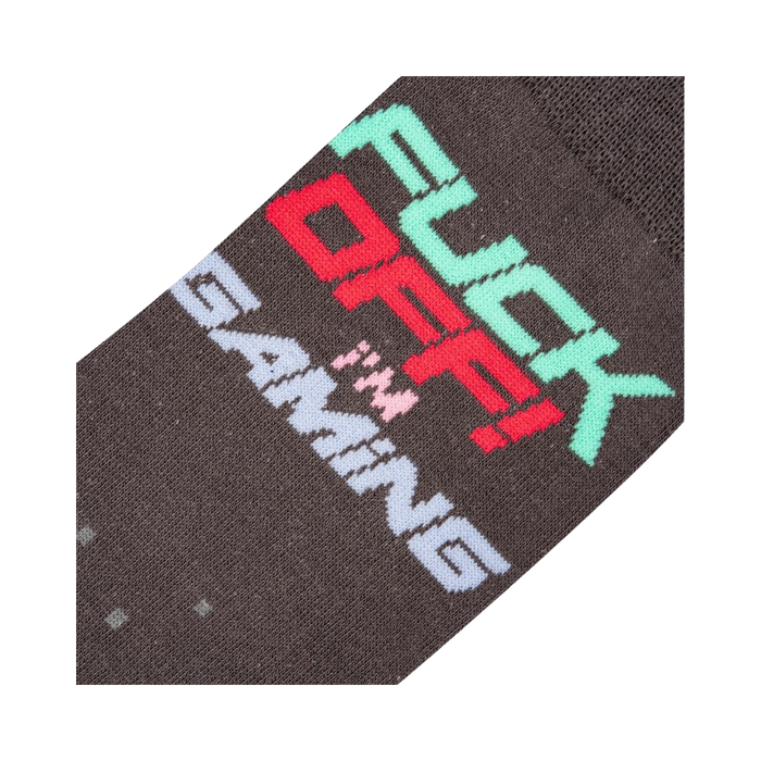 Close-up detail shot of the sock's 'Fuck Off I'm Gaming' text and pixelated design.
