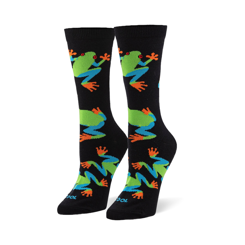 Black crew socks featuring a pattern of red-eyed tree frogs with bright green bodies, blue legs, and vibrant orange toes.