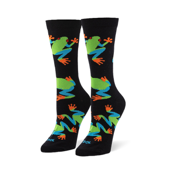 Black crew socks featuring a pattern of red-eyed tree frogs with bright green bodies, blue legs, and vibrant orange toes.