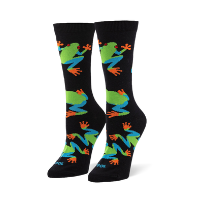 Black crew socks featuring a pattern of red-eyed tree frogs with bright green bodies, blue legs, and vibrant orange toes.