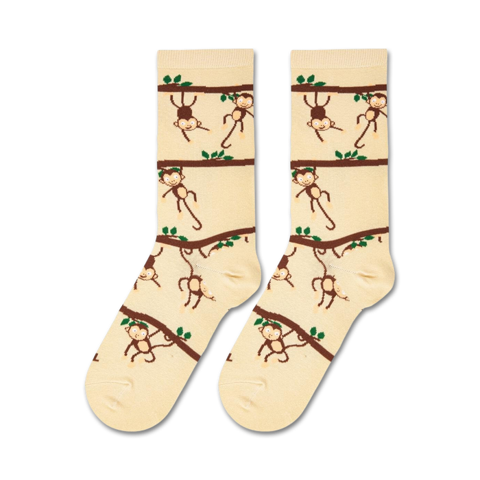 A close up of a pair of brown and cream colored socks with a pattern of monkeys hanging from tree branches.