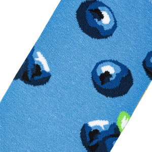 A close up of a pair of blue socks with a pattern of blueberries.