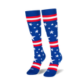 Two knee-high blue socks standing upright on a black surface, showing scattered white stars and red and white stripes.