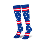 Two knee-high blue socks standing upright on a black surface, showing scattered white stars and red and white stripes.