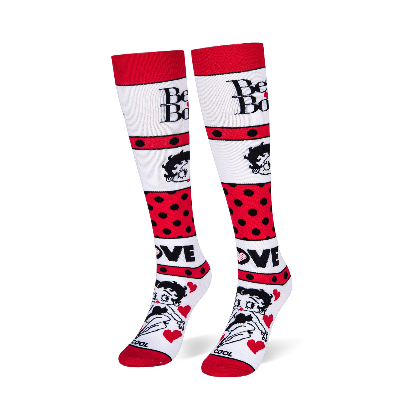 Angled studio shot of Betty Boop knee-high socks standing upright, highlighting the bold red polka dot stripes.
