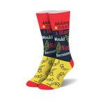 Pair of crew socks in red, black, and yellow.  One sock features a 1-star review graphic and shooting stars.