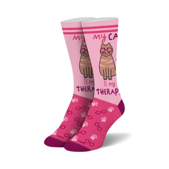 pink crew socks with paw prints, eyeglasses, and "my cat is my therapist" in white.  