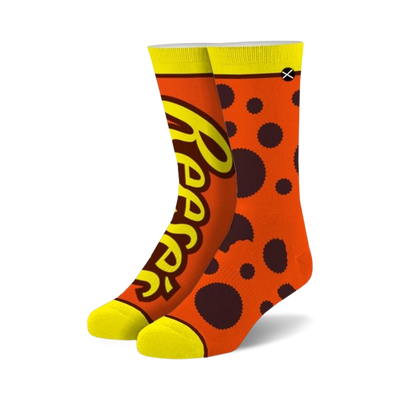 orange crew socks with "reeses" in yellow letters and brown polka dots perfect for men and women who love reeses.   