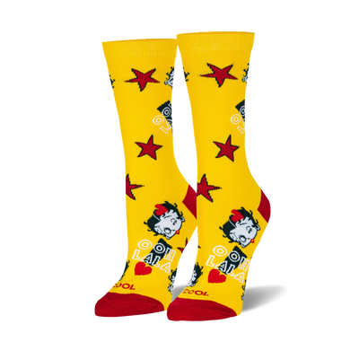 Pair of bright yellow crew socks with red toes and heels, featuring Betty Boop's face, red stars, and "OH LA LA" text.