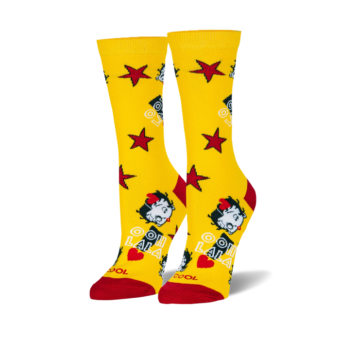 Pair of bright yellow crew socks with red toes and heels, featuring Betty Boop's face, red stars, and 