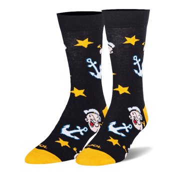 Black crew socks featuring a pattern of Popeye the Sailor Man's face, light blue anchors, and bright yellow stars.