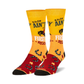 Pair of crew socks in yellow, red, and black.  Features a cowgirl riding a horse, horseshoes, and the text 'This ain't my first rodeo'.
