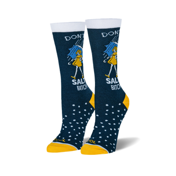 Pair of women's crew socks. Dark blue with white text reading 'Don't be a Salty Bitch', yellow girl illustration under an umbrella, and white polka dots. Yellow cuffs.