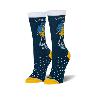 Pair of navy blue crew socks with white cuffs, yellow heels and toes. Features a person with a blue umbrella, rain, and "DON'T BE A SALTY BITCH" text.