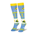 Angled view of knee-high socks displaying a white band filled with yellow buttercups and green leaves.