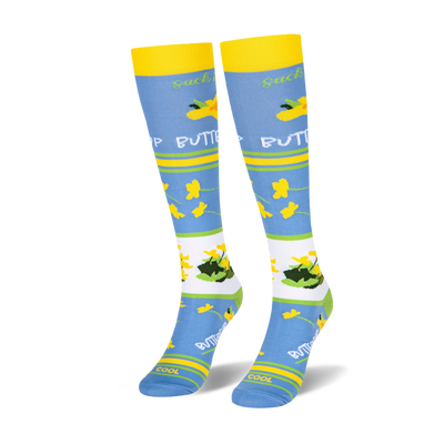 Pair of knee-high socks with yellow cuffs, light blue body, and green/white stripes. Features yellow buttercup flowers and 'Suck It Up Buttercup' text.