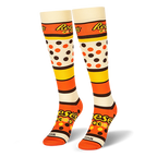 Pair of knee-high socks showing the Reese's Pieces logo, bold colored stripes, candy dots, and an orange toe box.