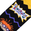 Close-up of black knitted sock fabric showing the white Rugrats logo, a purple zig-zag line, and Chuckie Finster's face.